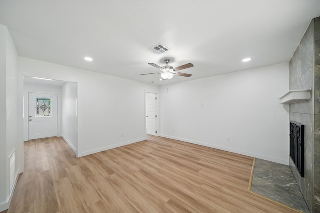 9711 Derrik Dr, Houston, TX 77080 - unfurnished living room featuring light wood-style floors, a tiled fireplace, visible vents, and a ceiling fan