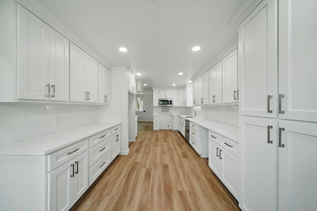 9711 Derrik Dr, Houston, TX 77080 - kitchen with a sink, decorative backsplash, light wood-style floors, appliances with stainless steel finishes, and recessed lighting