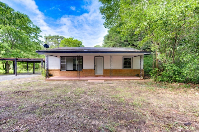 808 State Highway Loop 393, Goodrich, TX 77335 - ranch-style home featuring brick siding, covered porch, and a carport