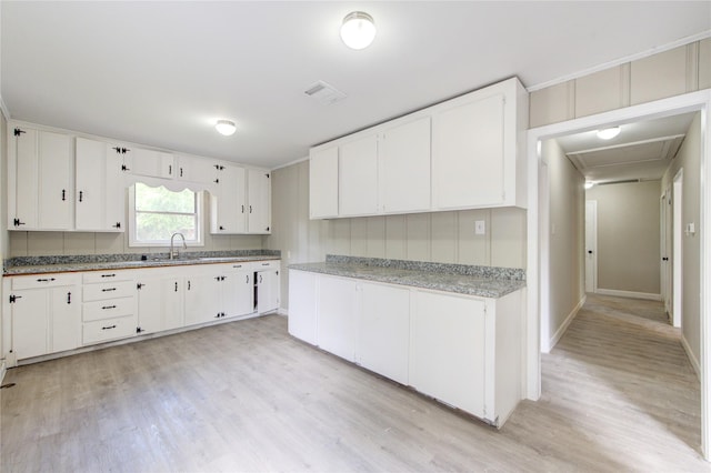808 State Highway Loop 393, Goodrich, TX 77335 - kitchen featuring a sink, light wood-style flooring, light countertops, and white cabinets