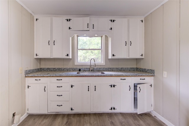 808 State Highway Loop 393, Goodrich, TX 77335 - kitchen featuring a sink, light wood finished floors, baseboards, and white cabinets