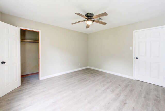 808 State Highway Loop 393, Goodrich, TX 77335 - unfurnished bedroom with wood finished floors, baseboards, a closet, and a ceiling fan
