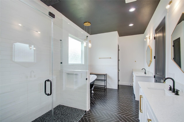 full bath with two vanities, a freestanding tub, a sink, and a shower stall