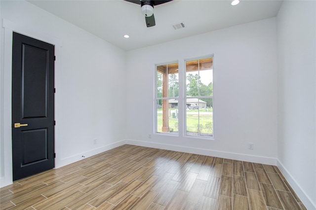 spare room featuring light wood-style flooring, visible vents, baseboards, and ceiling fan