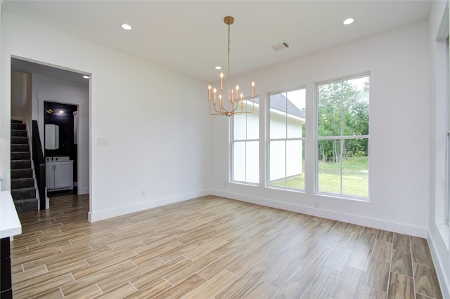 unfurnished dining area with stairway, a chandelier, light wood-style floors, baseboards, and visible vents