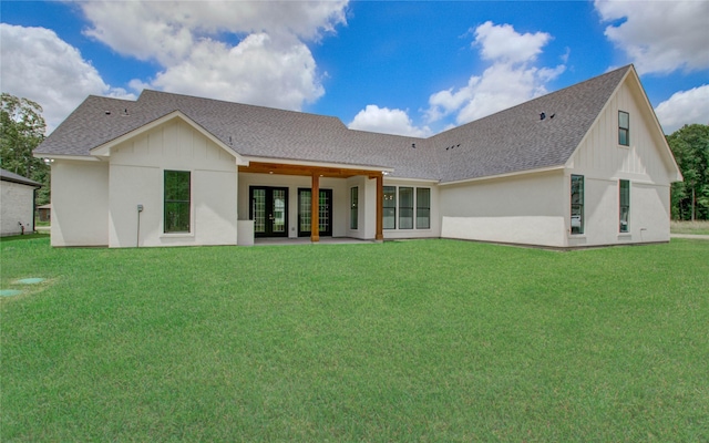 back of house featuring french doors, roof with shingles, a patio, and a lawn