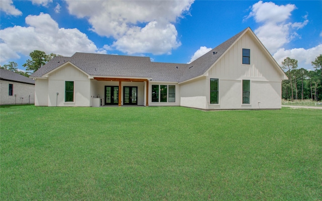 rear view of house featuring board and batten siding, a shingled roof, french doors, and a yard