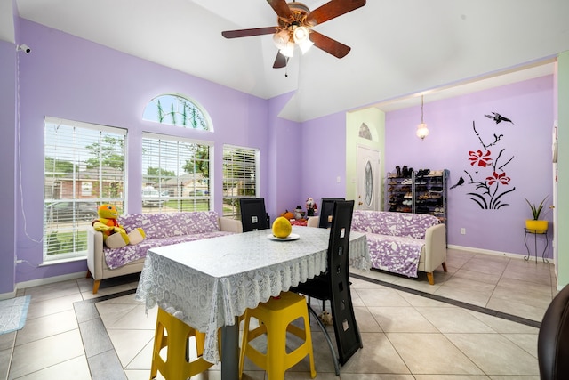 dining room featuring light tile patterned flooring, high vaulted ceiling, baseboards, and ceiling fan