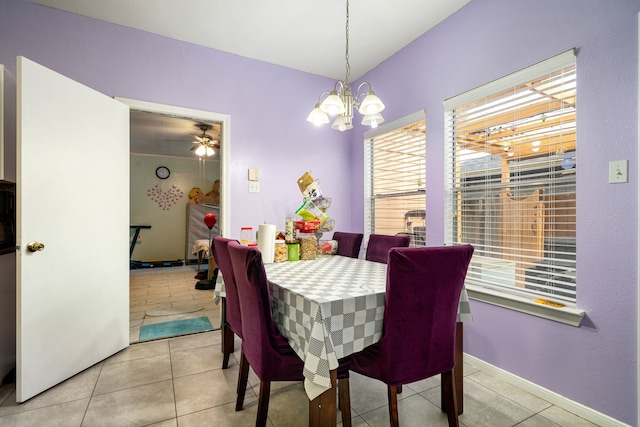dining area with ceiling fan with notable chandelier, plenty of natural light, and light tile patterned floors
