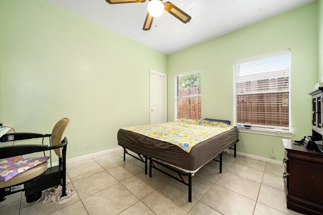 bedroom with light tile patterned flooring, baseboards, and ceiling fan