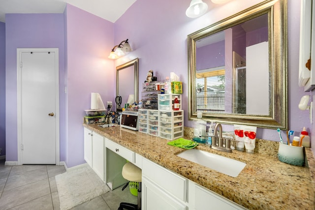 full bathroom with vanity, baseboards, a shower with door, and tile patterned flooring