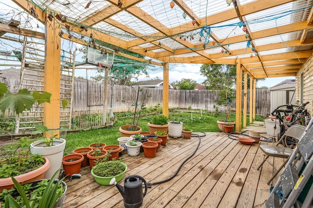 wooden deck featuring a pergola, a storage shed, a fenced backyard, an outdoor structure, and a yard