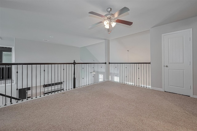 carpeted spare room with ceiling fan, baseboards, and visible vents