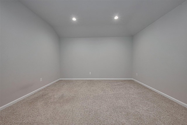 empty room with light carpet, vaulted ceiling, baseboards, and recessed lighting