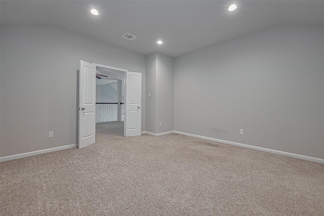 unfurnished bedroom with recessed lighting, vaulted ceiling, visible vents, and light colored carpet