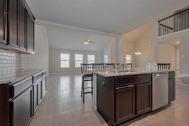 kitchen with backsplash, lofted ceiling, ceiling fan with notable chandelier, dishwasher, and a breakfast bar area