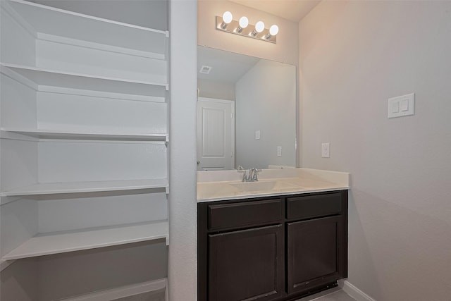 bathroom featuring visible vents, baseboards, and vanity