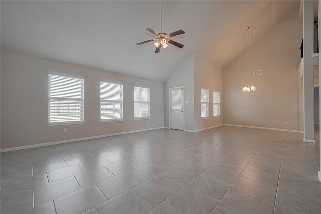unfurnished living room with high vaulted ceiling, a wealth of natural light, light tile patterned flooring, and ceiling fan with notable chandelier
