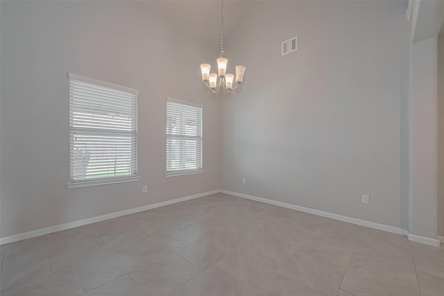 spare room with high vaulted ceiling, baseboards, a chandelier, and visible vents