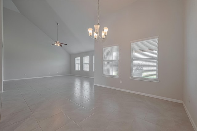 empty room featuring light tile patterned floors, baseboards, high vaulted ceiling, and ceiling fan with notable chandelier