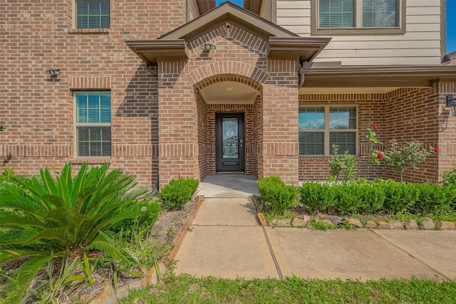 property entrance featuring brick siding