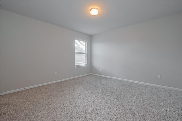carpeted spare room with baseboards
