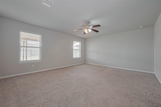 unfurnished room with baseboards, visible vents, light colored carpet, and ceiling fan