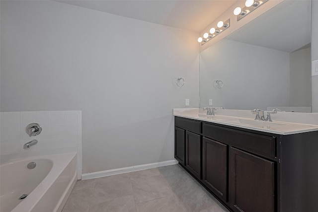 bathroom featuring tile patterned floors, a sink, double vanity, baseboards, and a garden tub