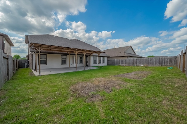 rear view of house with a lawn, a patio area, a fenced backyard, and central AC unit
