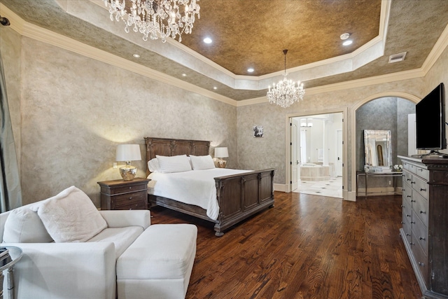 bedroom with an inviting chandelier, dark wood finished floors, ensuite bathroom, a tray ceiling, and visible vents