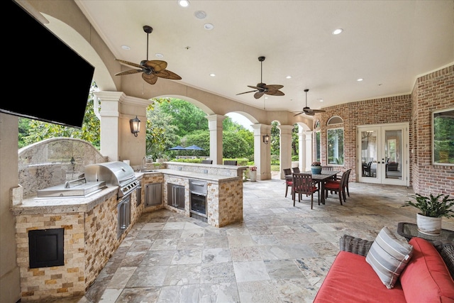 view of patio / terrace featuring area for grilling, french doors, a sink, an outdoor kitchen, and outdoor dining space