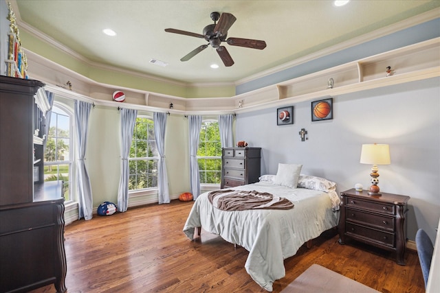 bedroom with crown molding, multiple windows, wood finished floors, and visible vents