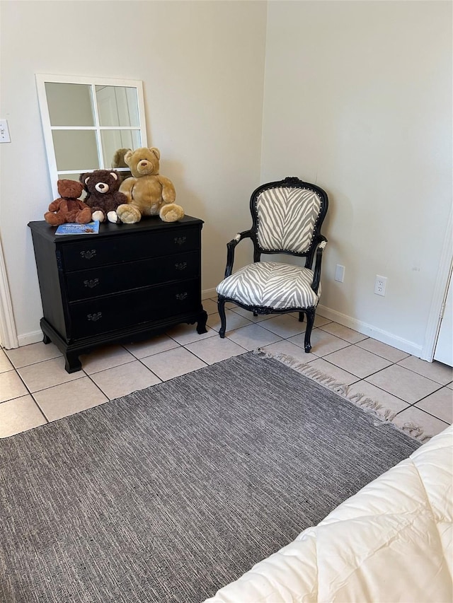 sitting room featuring tile patterned flooring and baseboards