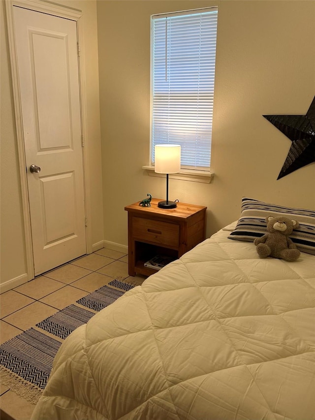 bedroom with baseboards and light tile patterned floors