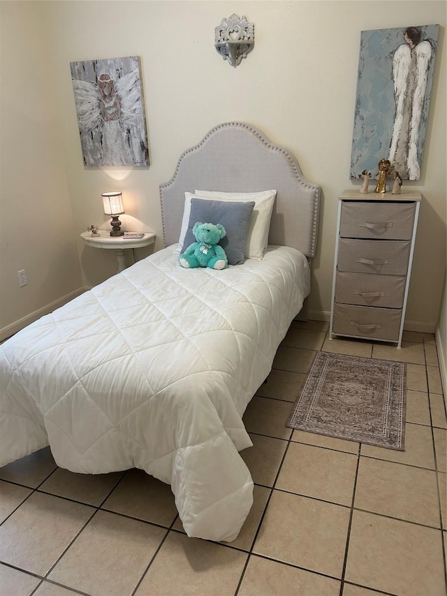 bedroom with baseboards and tile patterned flooring
