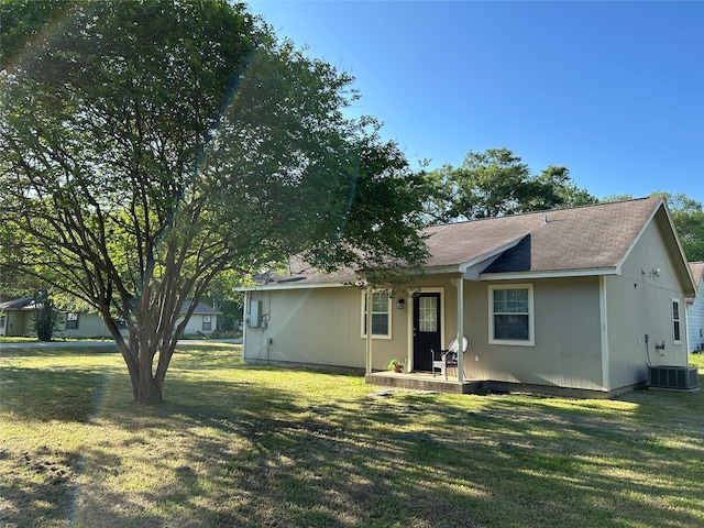 rear view of house featuring a lawn, central AC, and a porch