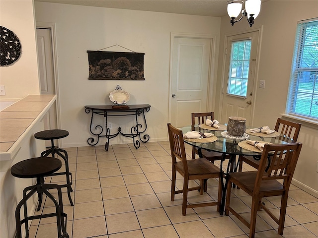 dining room with baseboards, a chandelier, and light tile patterned floors