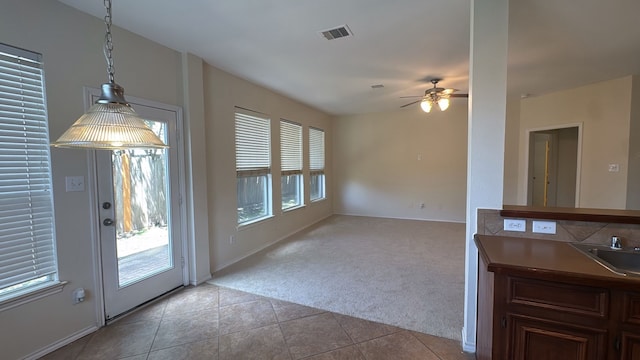 4923 Lake Gladewater Ct, Richmond, TX 77407 - unfurnished dining area with light colored carpet, light tile patterned floors, ceiling fan, baseboards, and a sink