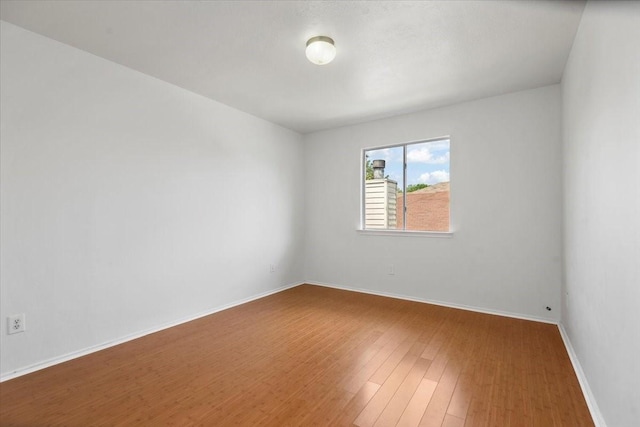 unfurnished room featuring baseboards and wood finished floors