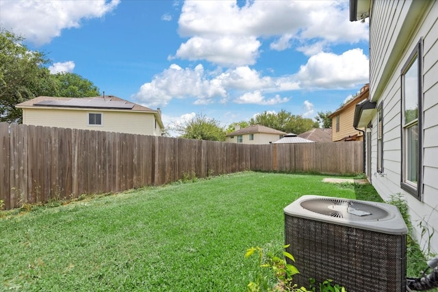 view of yard with central AC and a fenced backyard