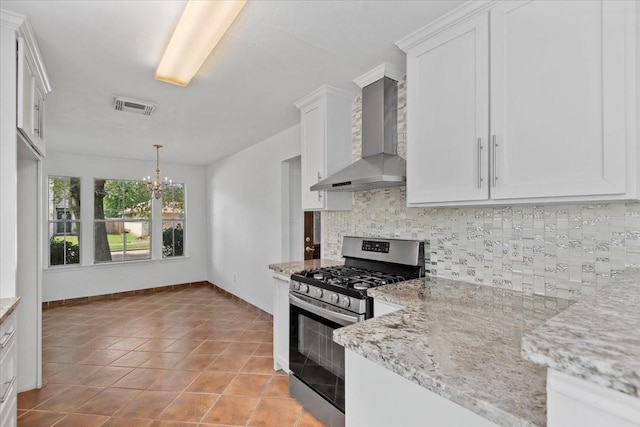 kitchen featuring stainless steel gas range, visible vents, an inviting chandelier, backsplash, and wall chimney range hood