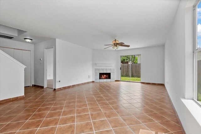 unfurnished living room with a ceiling fan, tile patterned flooring, visible vents, and a tiled fireplace