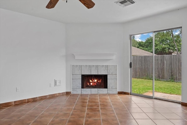 unfurnished living room featuring a tile fireplace, visible vents, tile patterned flooring, and ceiling fan