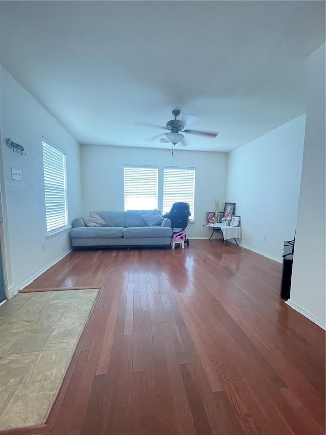 living area with baseboards, ceiling fan, and hardwood / wood-style floors