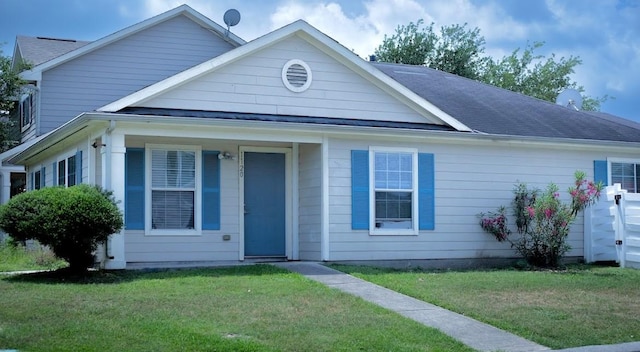 view of front of home featuring a shingled roof and a front yard