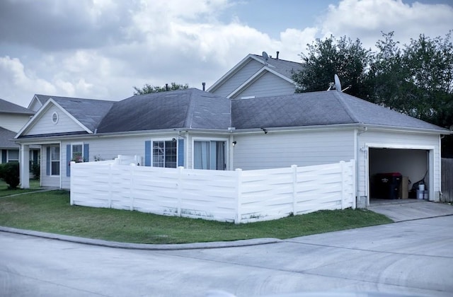 view of home's exterior featuring an attached garage, driveway, and fence private yard