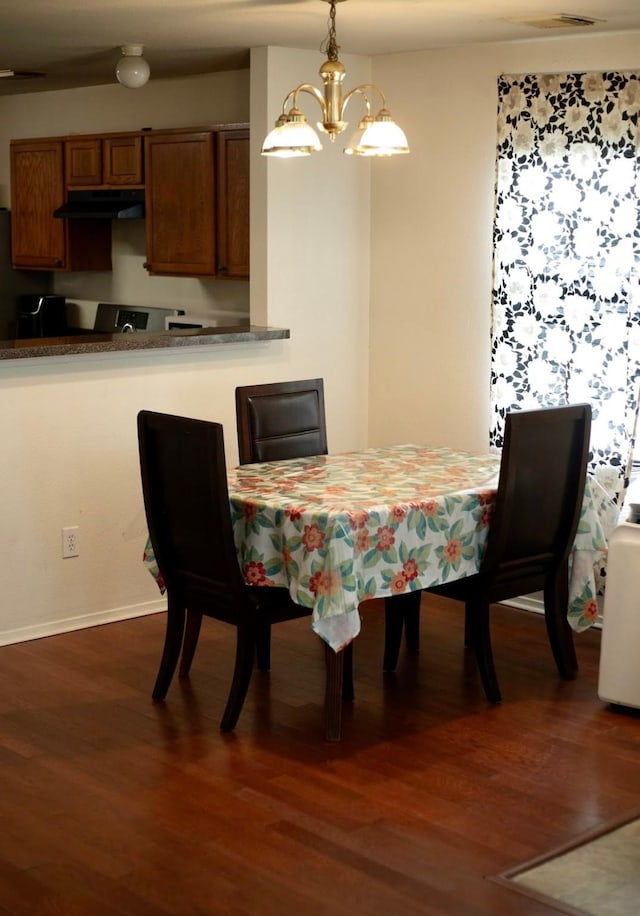 dining space featuring baseboards, a chandelier, and dark wood-style floors