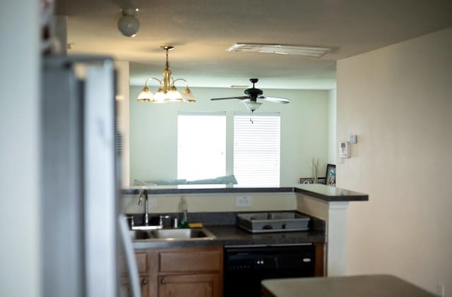 kitchen with ceiling fan, dark countertops, refrigerator, a sink, and black dishwasher