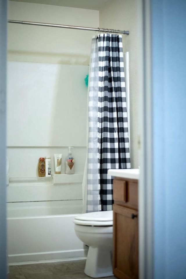 bathroom with toilet, shower / bathtub combination with curtain, and vanity