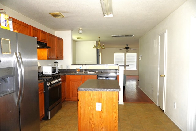 1120 Verde Trails Dr, Houston, TX 77073 - kitchen with appliances with stainless steel finishes, under cabinet range hood, a peninsula, a center island, and a ceiling fan